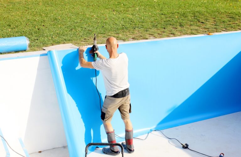 A worker welds plastic cover for water pool. Water pool cover replacement. Plastic Welding Machine. Swimming pool care concept.